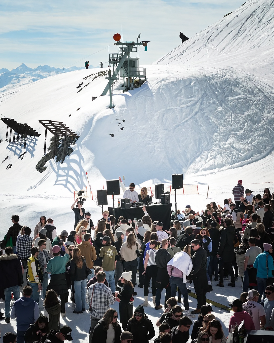 ROOM:SRVC DJs Sascha and Olivia playing a sundowner set on a snowy Tyrolean mountain, crowd in front of the booth