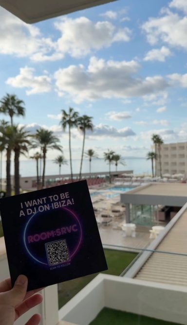 ROOM:SRVC promotional QR code at Ibiza rooftop overlooking the sea